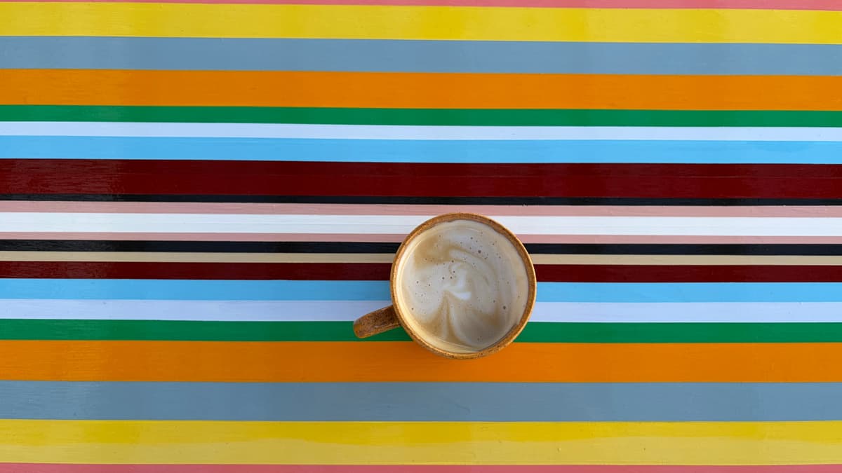 A coffee on the Strip Painting table in the 300 West laneway — Walk the Line